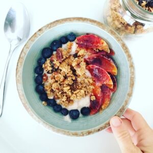 an arial view of granola, blood orange, blueberries and vegan yogurt