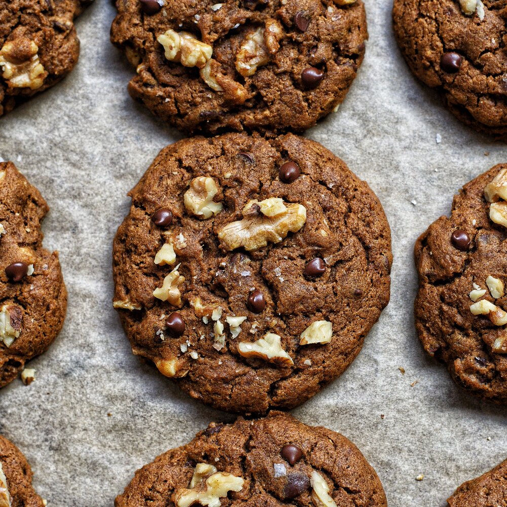 close up view of a freshly baked pumpkin walnuts chocolate chip cookie by teri-ann carty