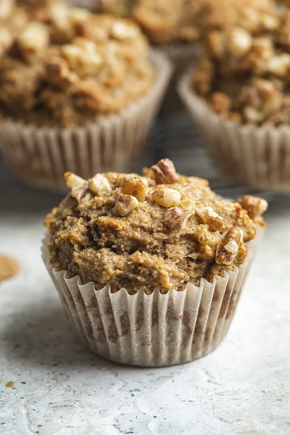 a close up of a healthy and delicious muffin with walnuts on top