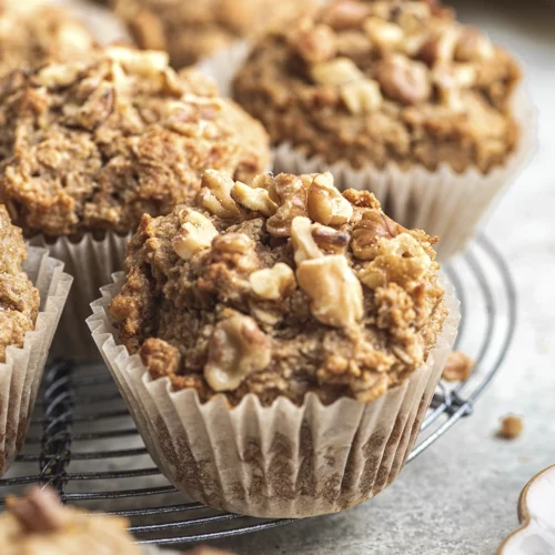A close up of muffins on a cooling tray with a lightly toasted crumble of walnuts on top