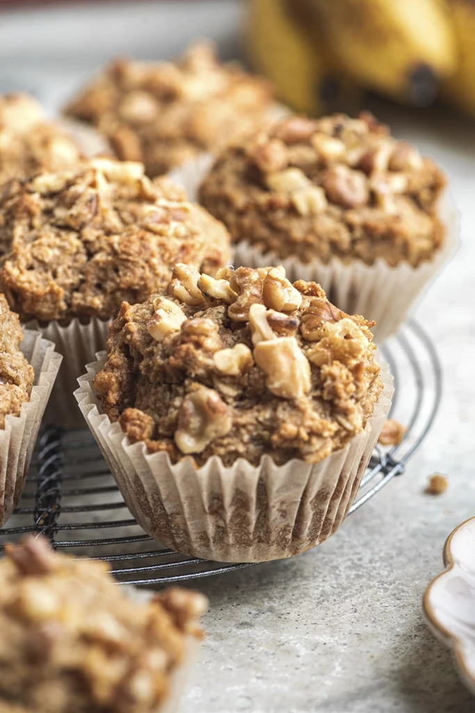A close up of muffins on a cooling tray with a lightly toasted crumble of walnuts on top