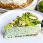 vibrant slice of Vegan Kiwi Lime Cheesecake on a speckled plate