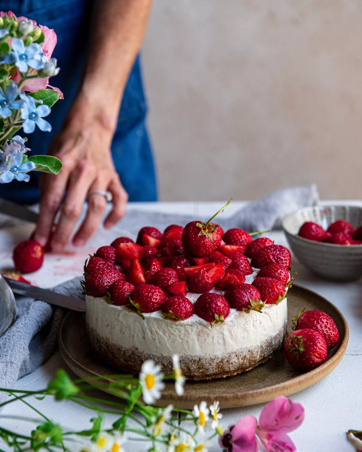 person slicing cake. strawberry cheesecake vegan