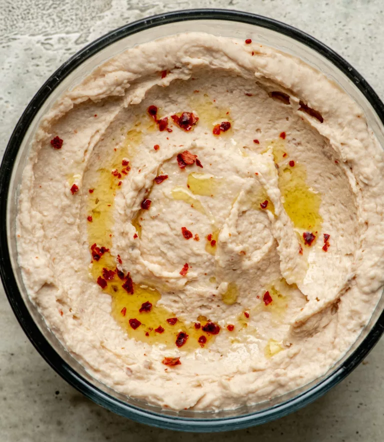 white bean hummus in a bow with olive oil and chili flakes on top