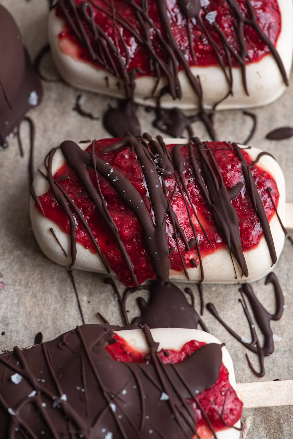 Jam covered ice cream bars with chocolate drizzled on top