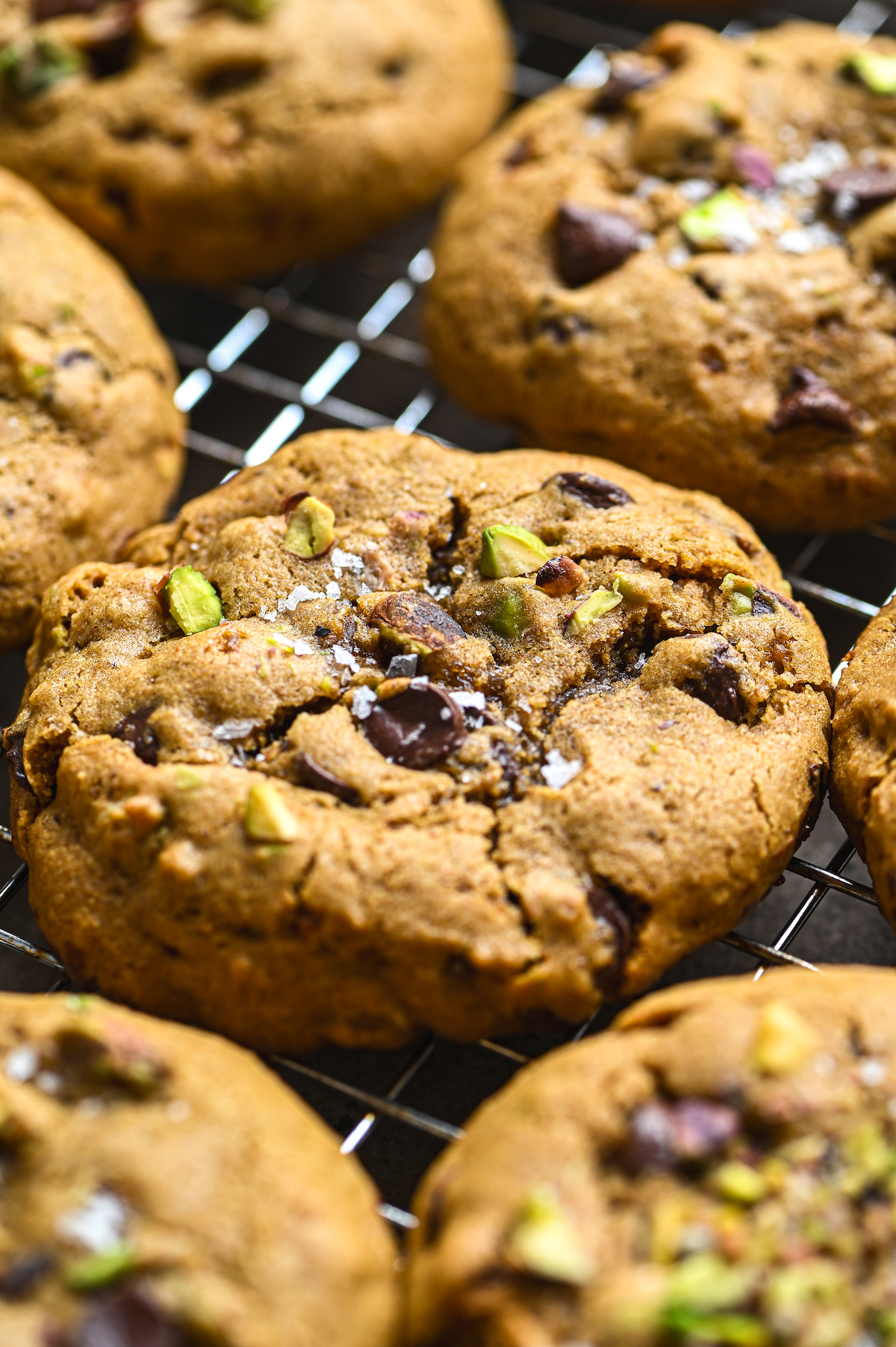 Close up of freshly baked chocolate chip and pistachio gluten free cookies with sea salt flakes by teri-ann carty