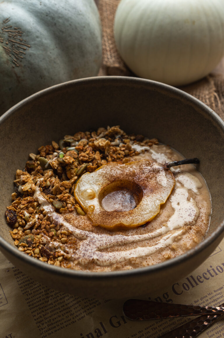 grey bowl with oats, pear slice, cinnamon and baked homemade granola by teri-ann carty
