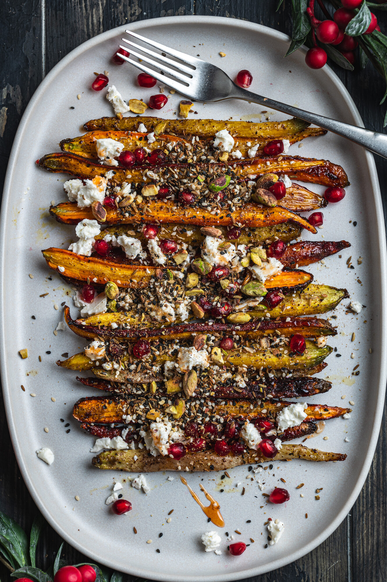 plate with freshly roasted carrots decorated with cheese and baked seeds by teri-ann carty