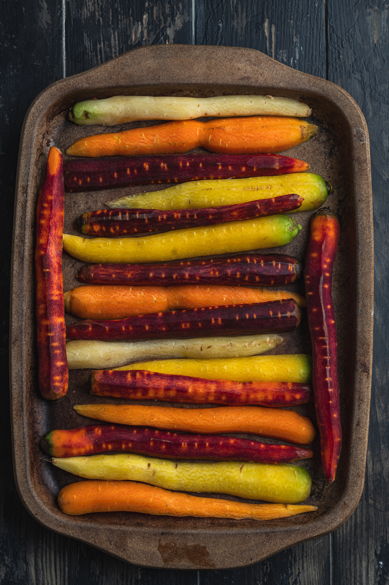 casserole with peeled local carrots with different colors by teri-ann carty