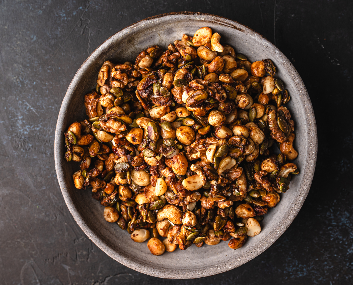 close-up of glossy candied walnuts, cashews, hazelnuts and pumpkin seeds