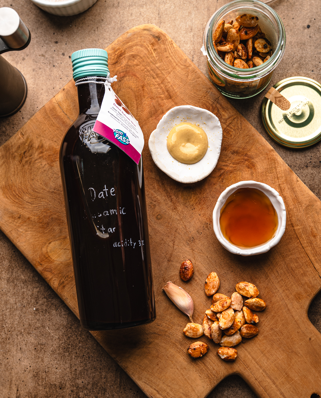 date balsamic vinegar, dijon mustard, maple syrup, garlic and toasted nuts arranged for salad dressing