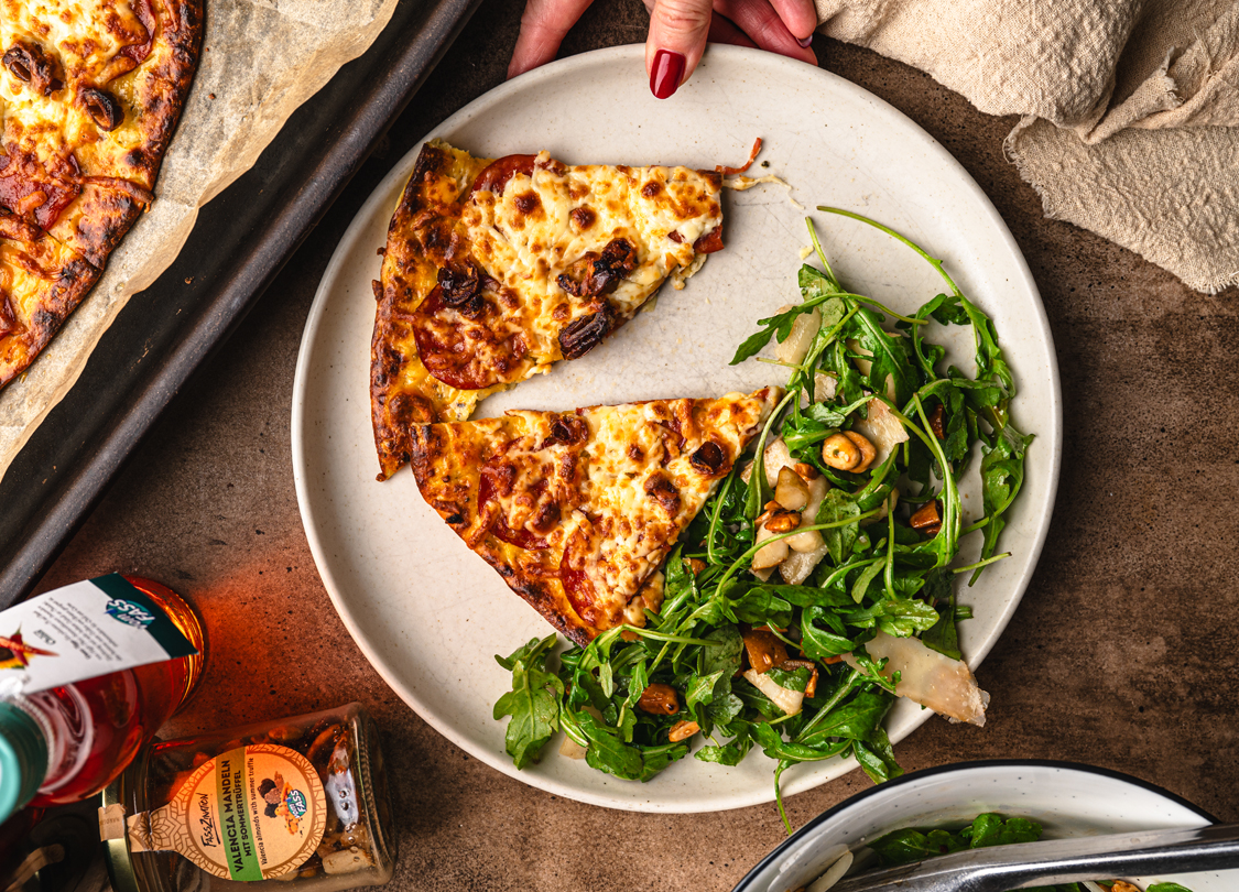 high-protein pepperoni pizza served with arugula pear salad and toasted nuts