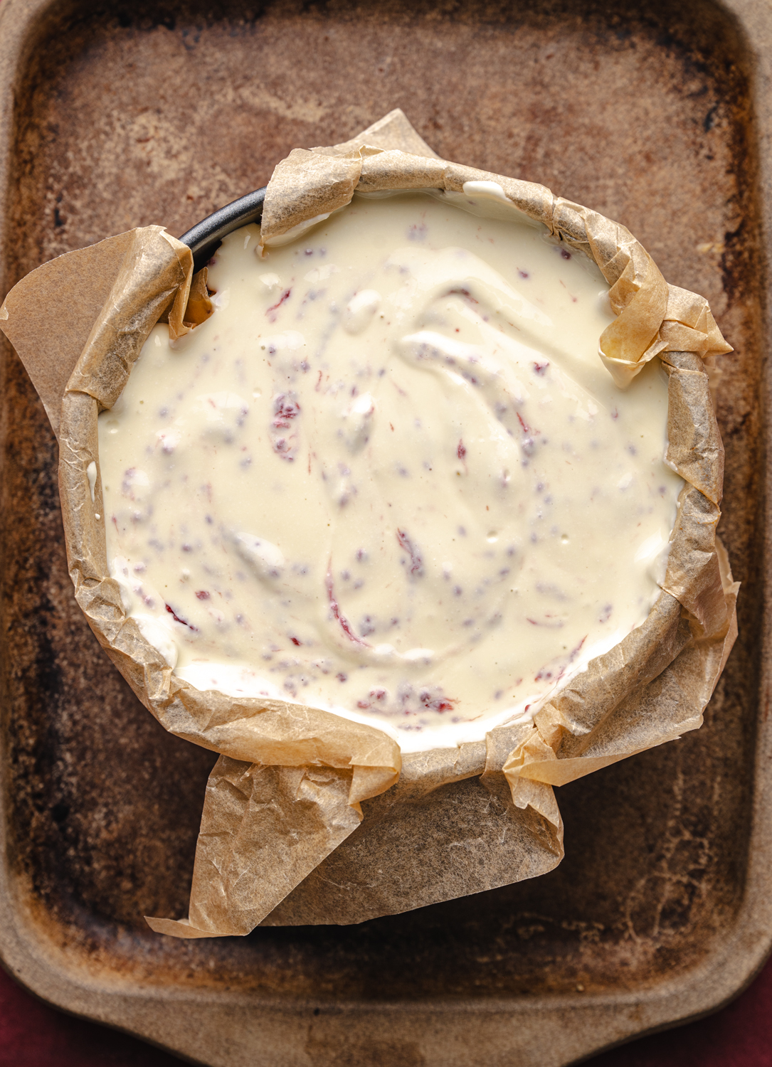 unbaked strawberry cheesecake filling in a parchment-lined pan