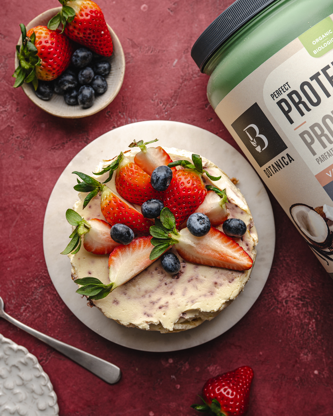 high-protein strawberry cheesecake topped with strawberries and blueberries