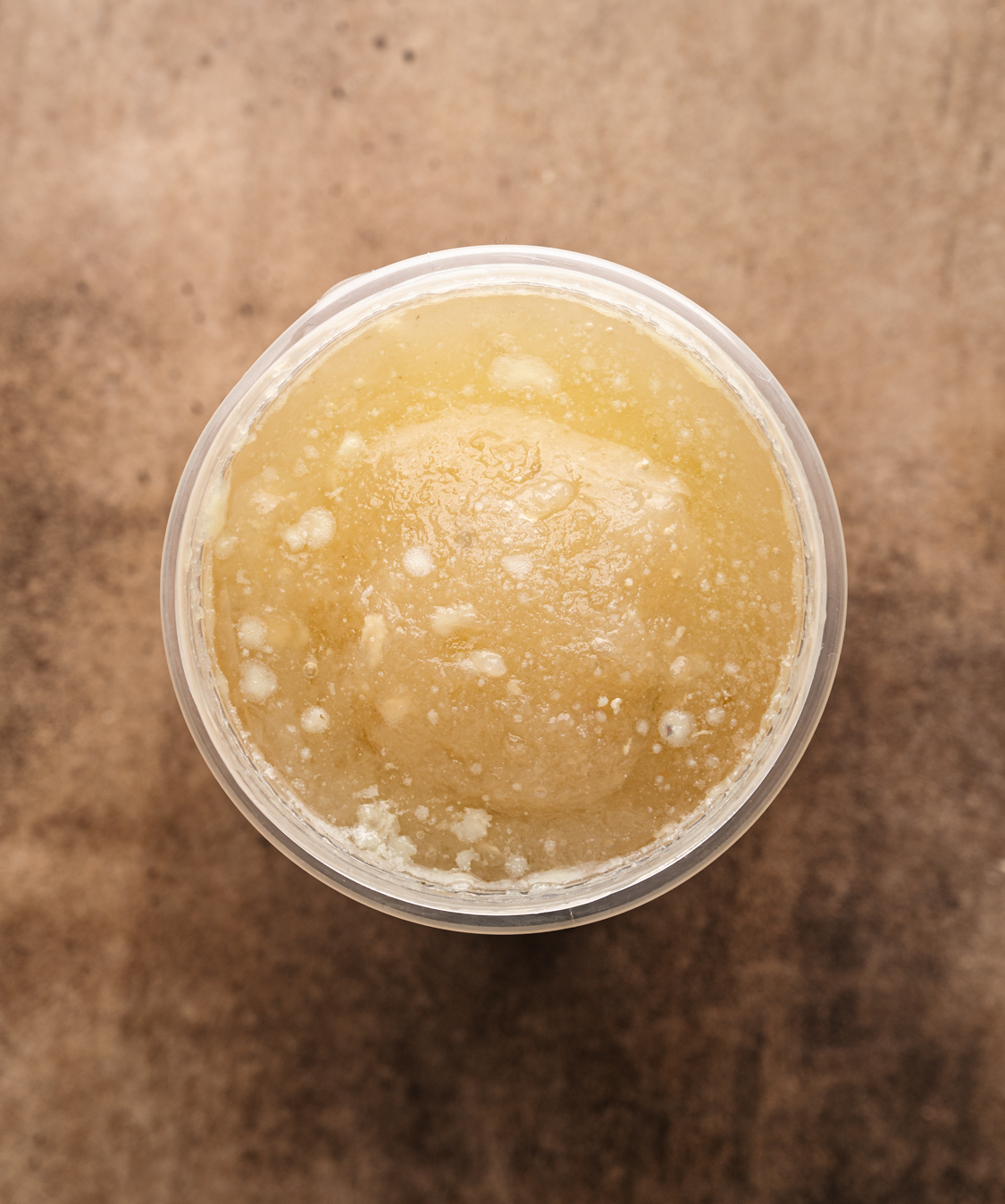 plastic kitchen container filled with frozen broth