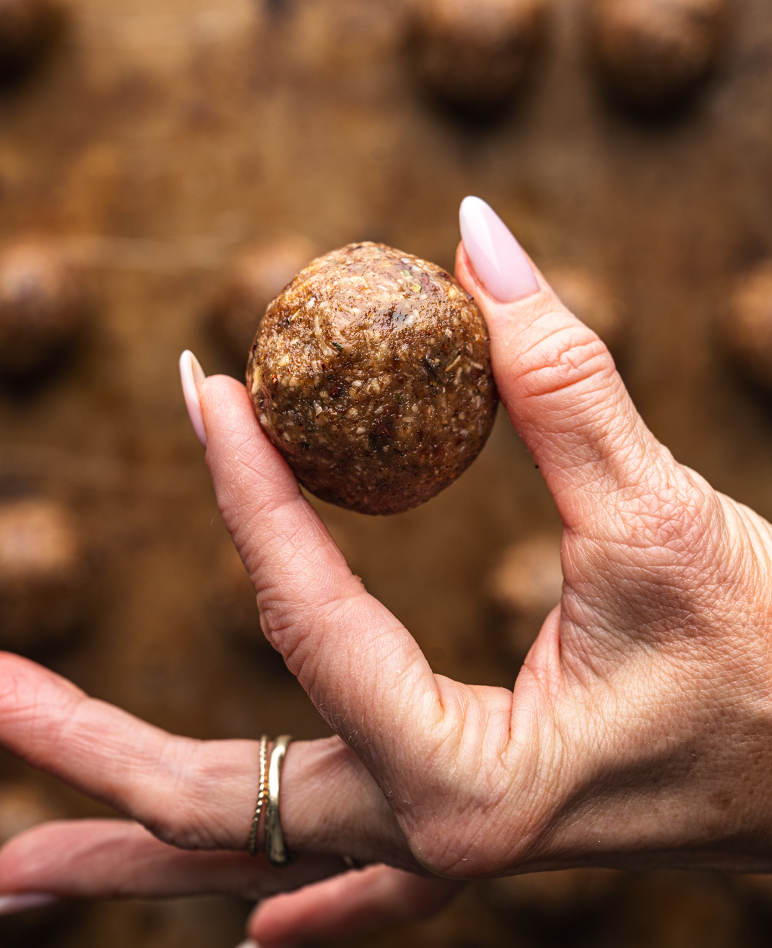 banana date bliss ball held between two fingers
