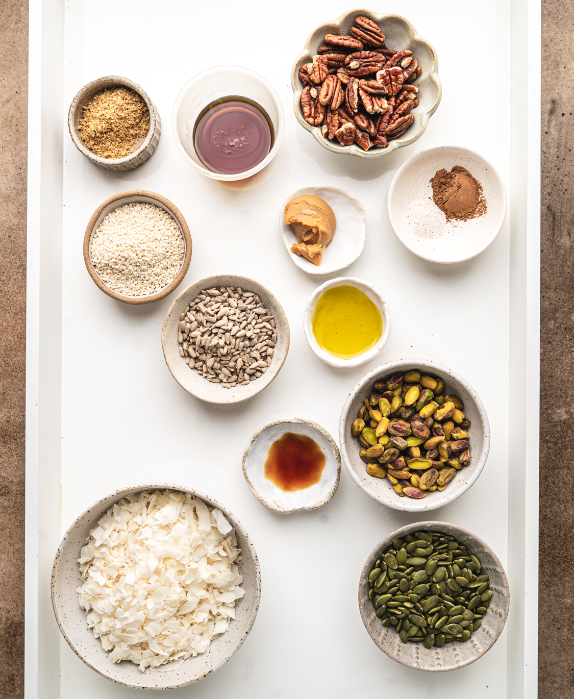 all the ingredients for maple miso grain free granola cookies all in individual ramekins and bowls on a white tray