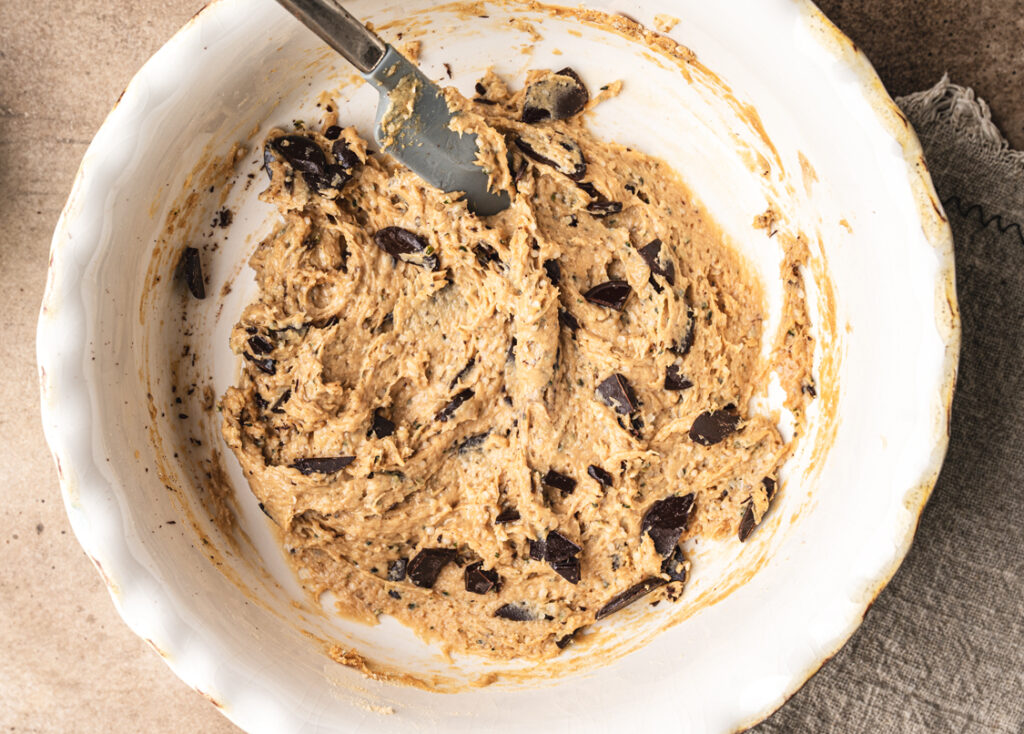 progress shot of spatula mixing ingredients of chocolate chip cookies