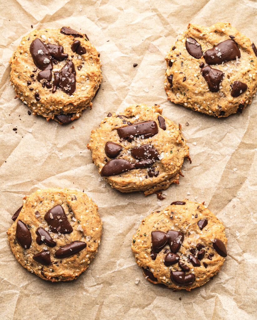 five chocolate chip protein cookies on parchment paper