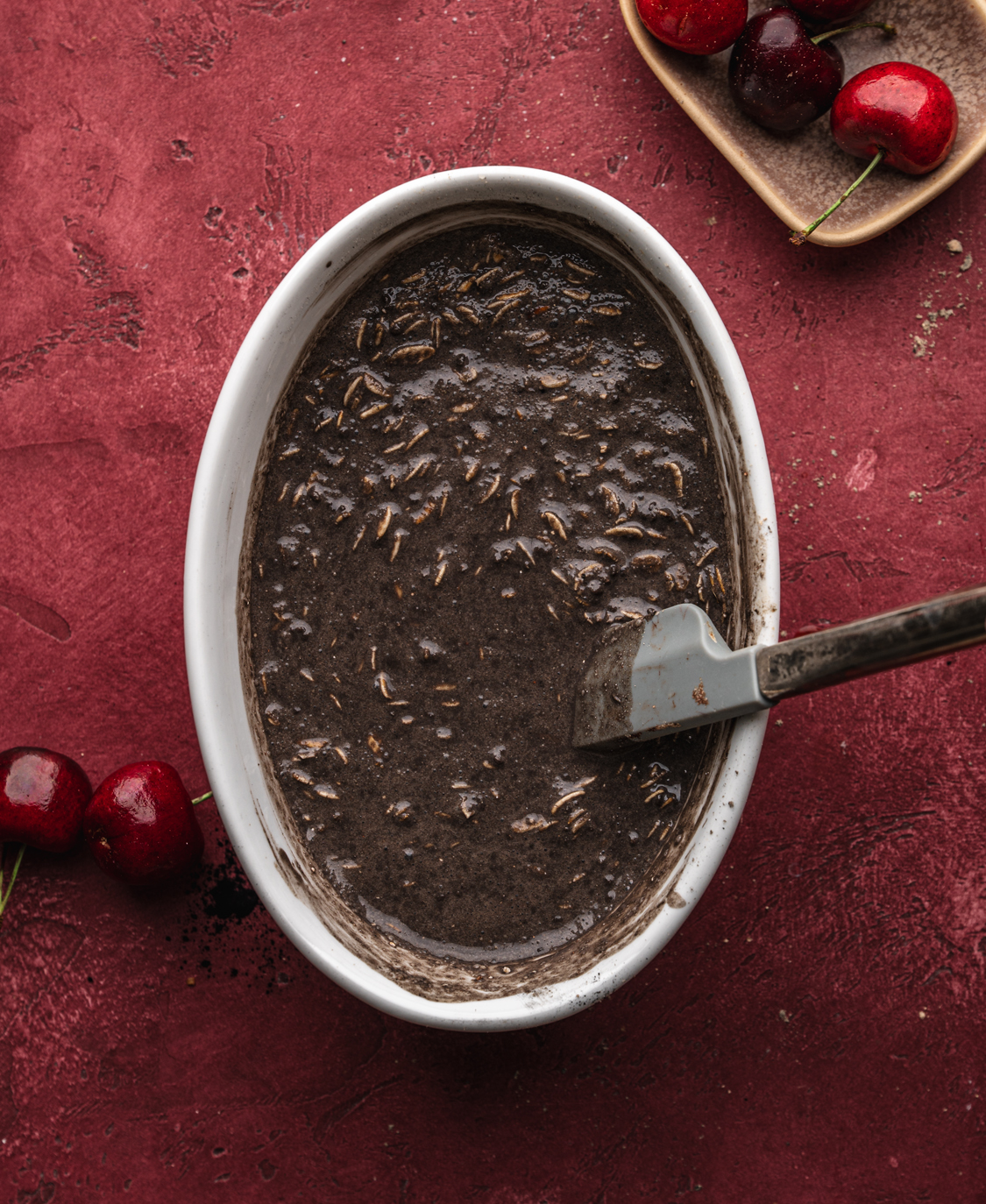 black forest overnight oats being mixed in a white ramekin
