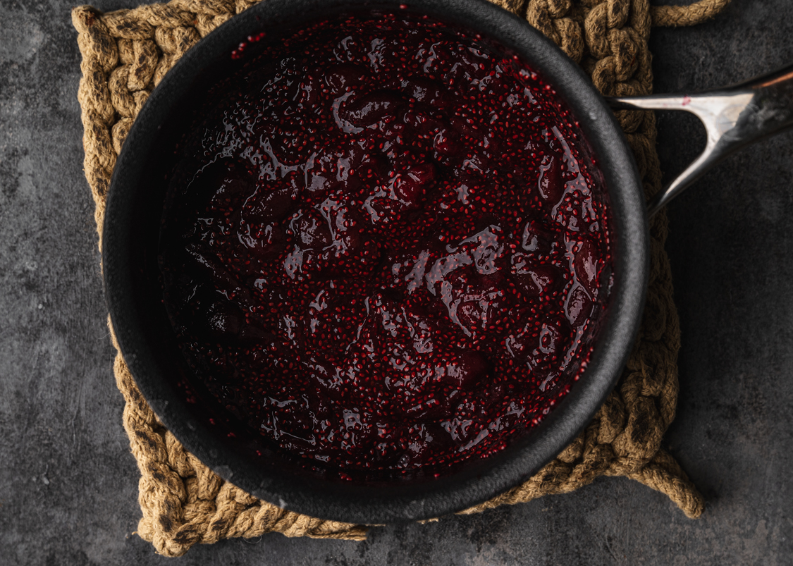 cooking pan on a trivet with homemade cherry jam cooling