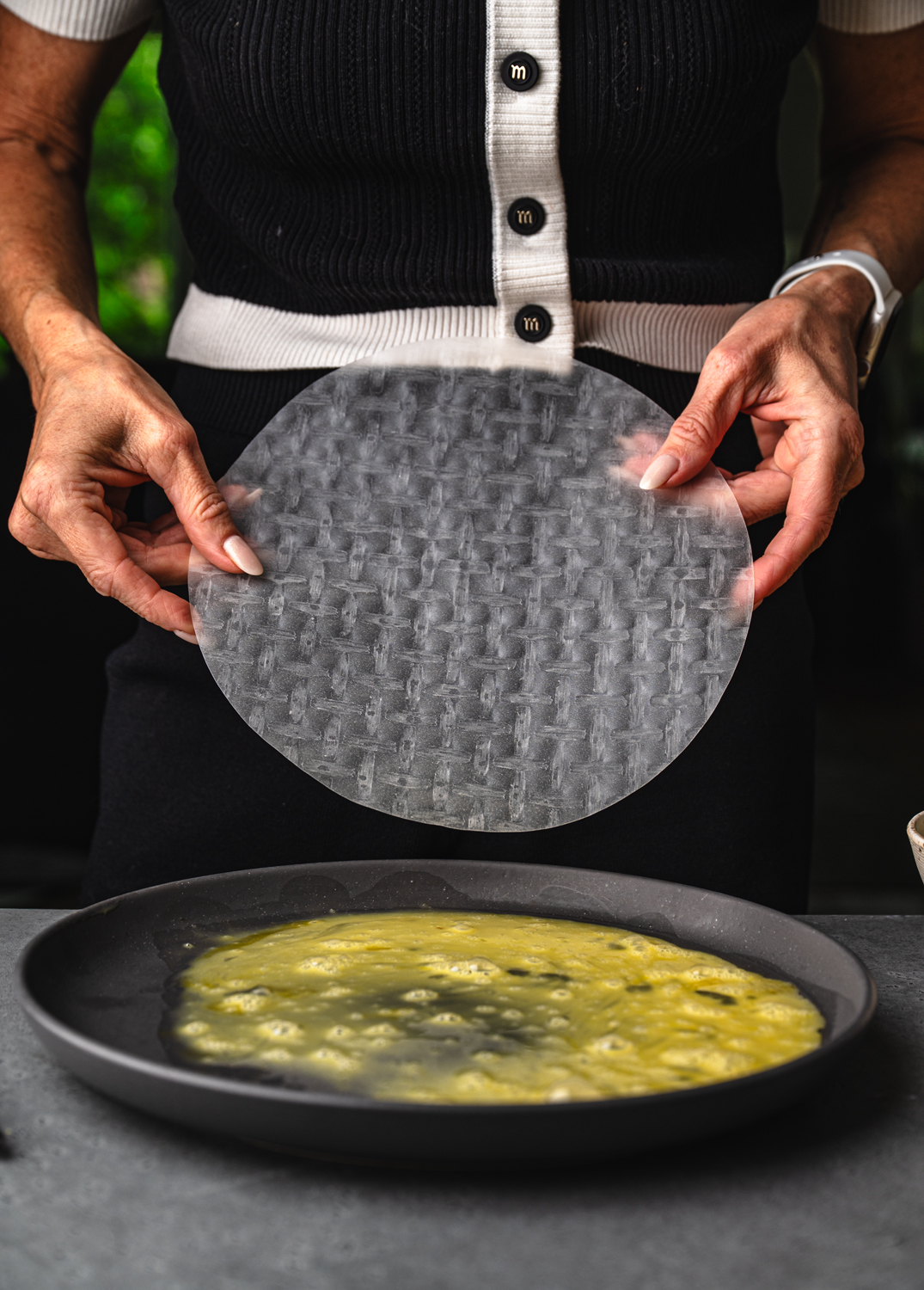teri-ann carty holding a rice paper wrap before submerging it into egg