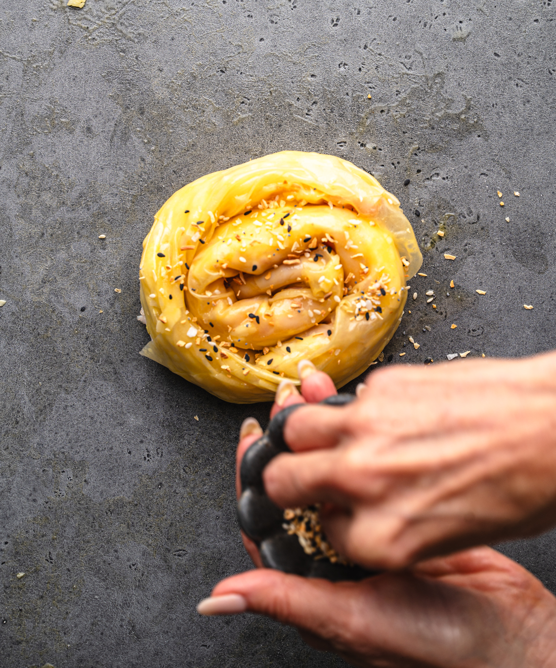 hand putting everything bagel spice on top of a rice paper croque monsieur before placing it in the air fryer