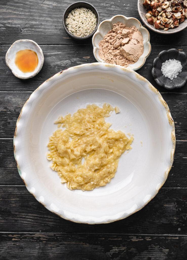 mashed banana in a white bowl to make nutella cookies