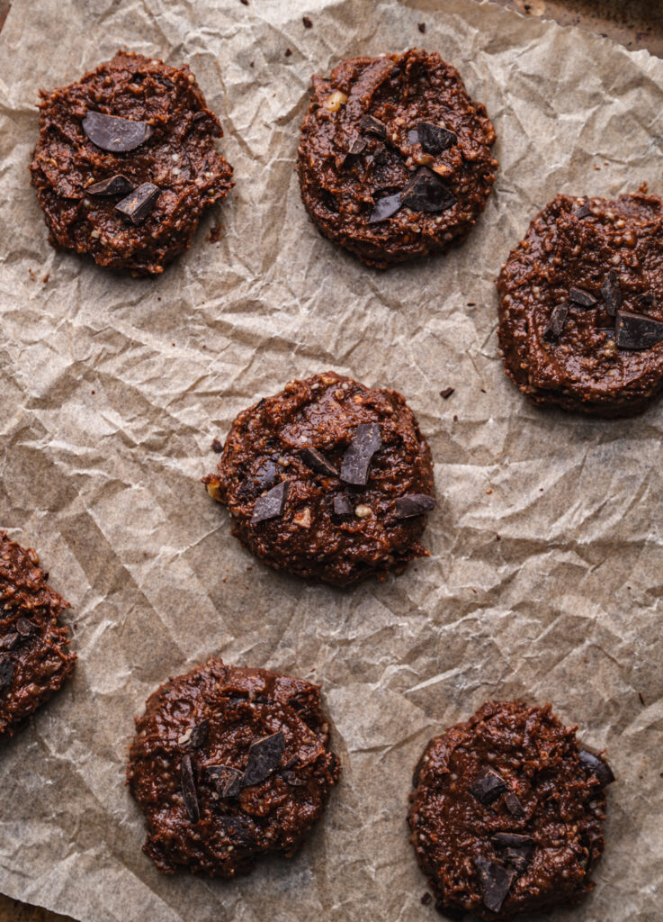 seven unbaked flourless nutella cookies on a baking tray before they've gone in the oven