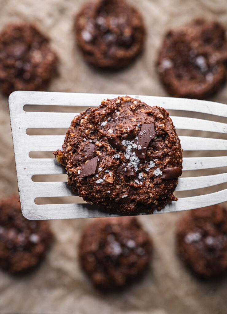 spatula holding one nutella cookie over the other out of focus flourless high protein nutella cookies