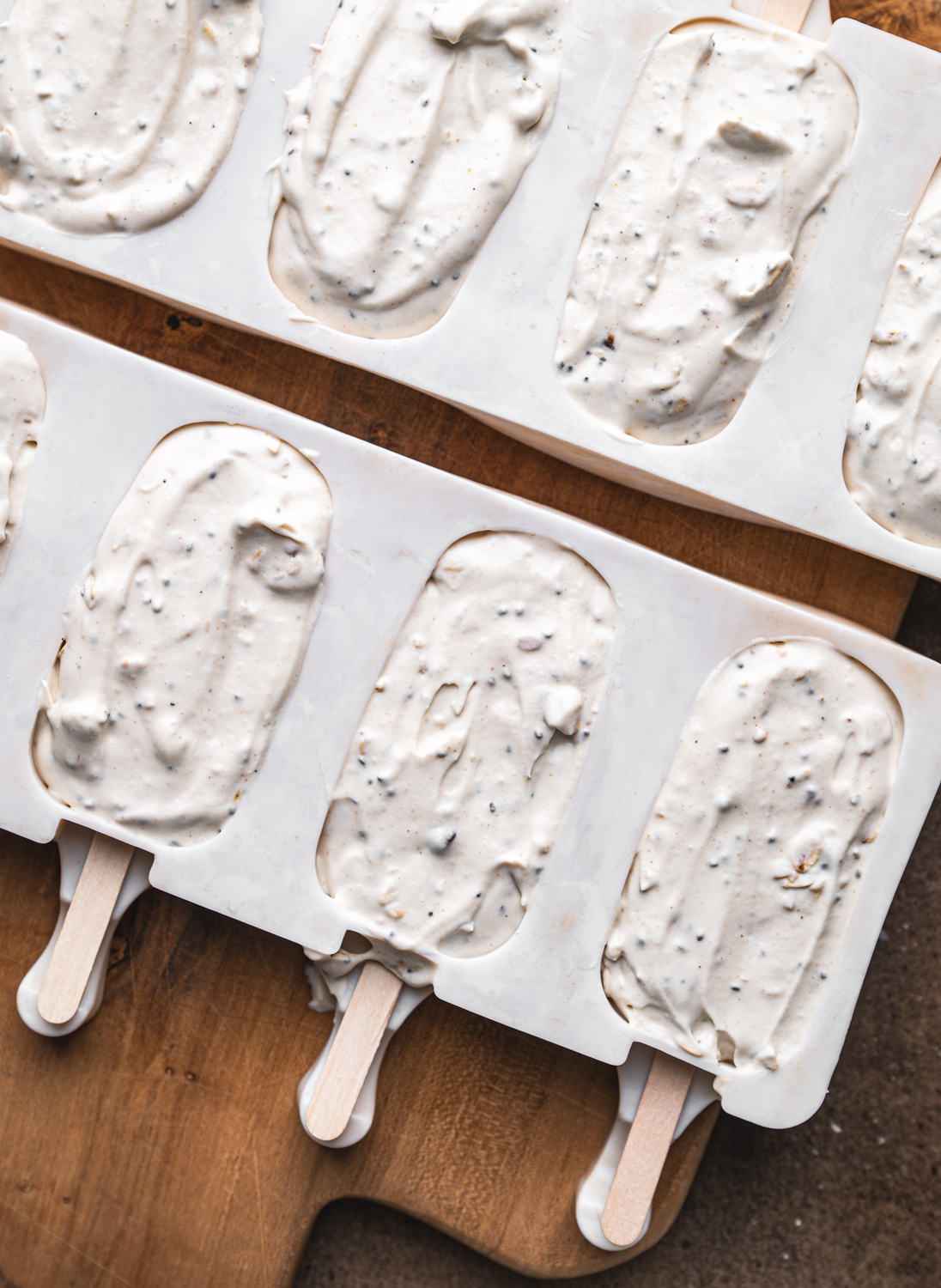 creamy mocha ice cream mixture spooned into popsicle molds with wooden sticks