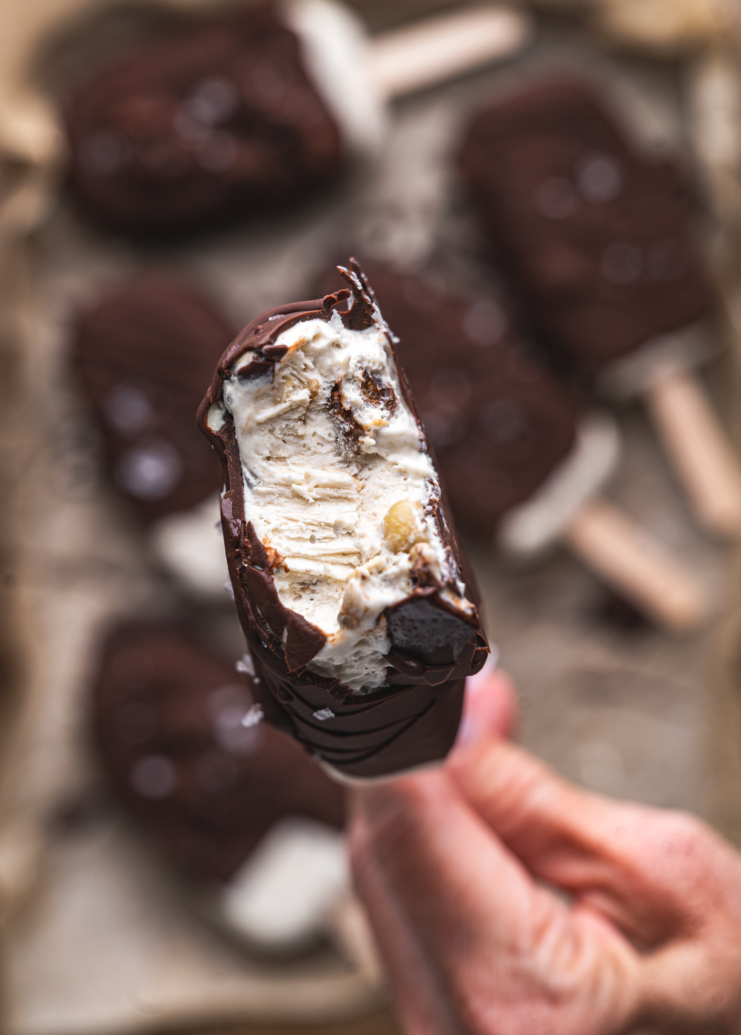 bitten chocolate-covered mocha ice cream bar showing its creamy center and crunchy mix-ins